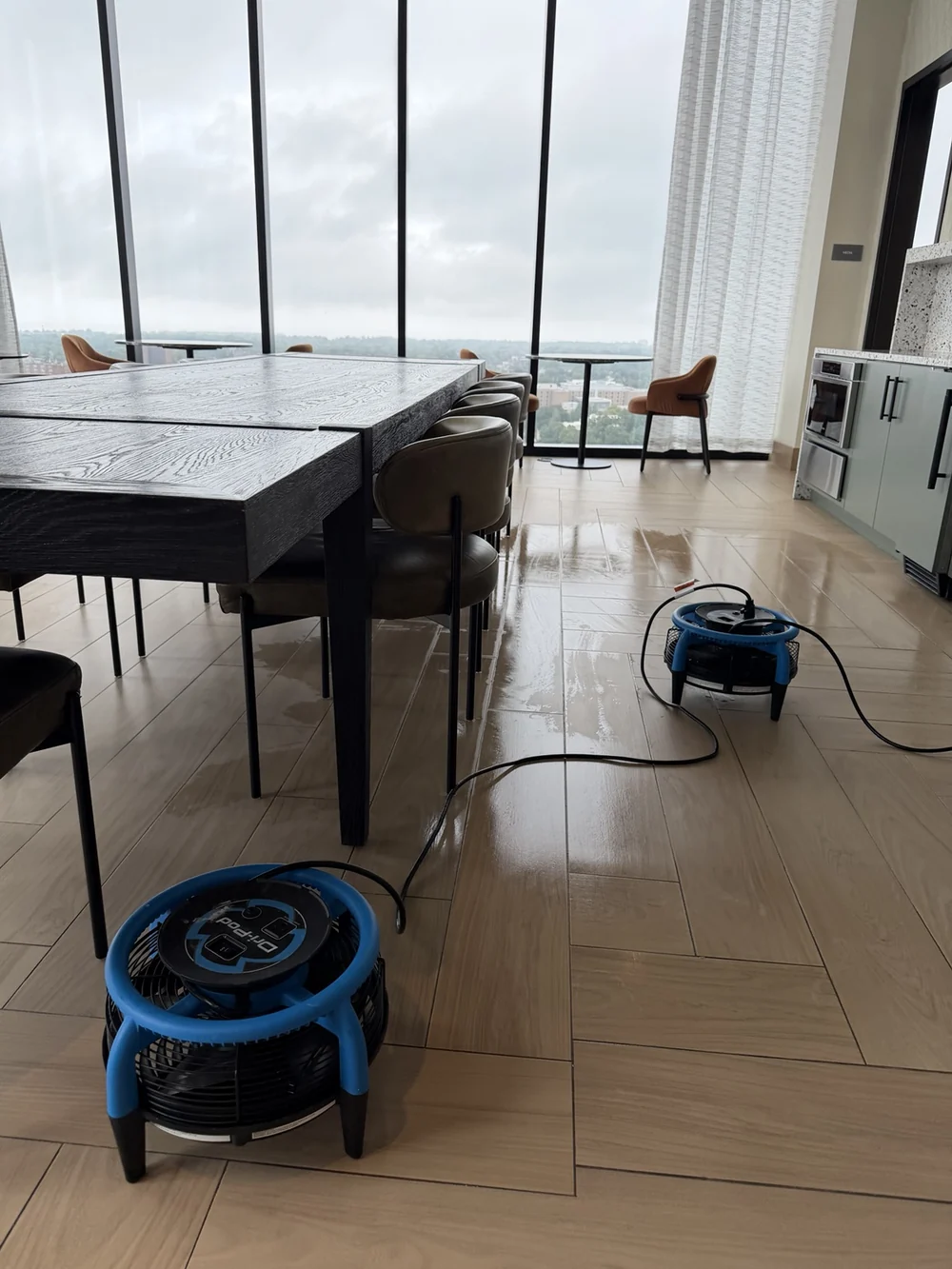 Commercial lounge floor with two air movers and visible reflections