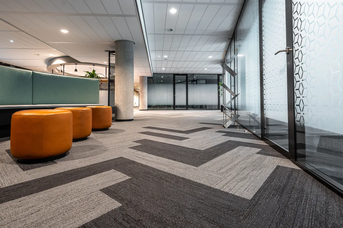 Representative photograph of patterned commercial carpet in a shared office interior.